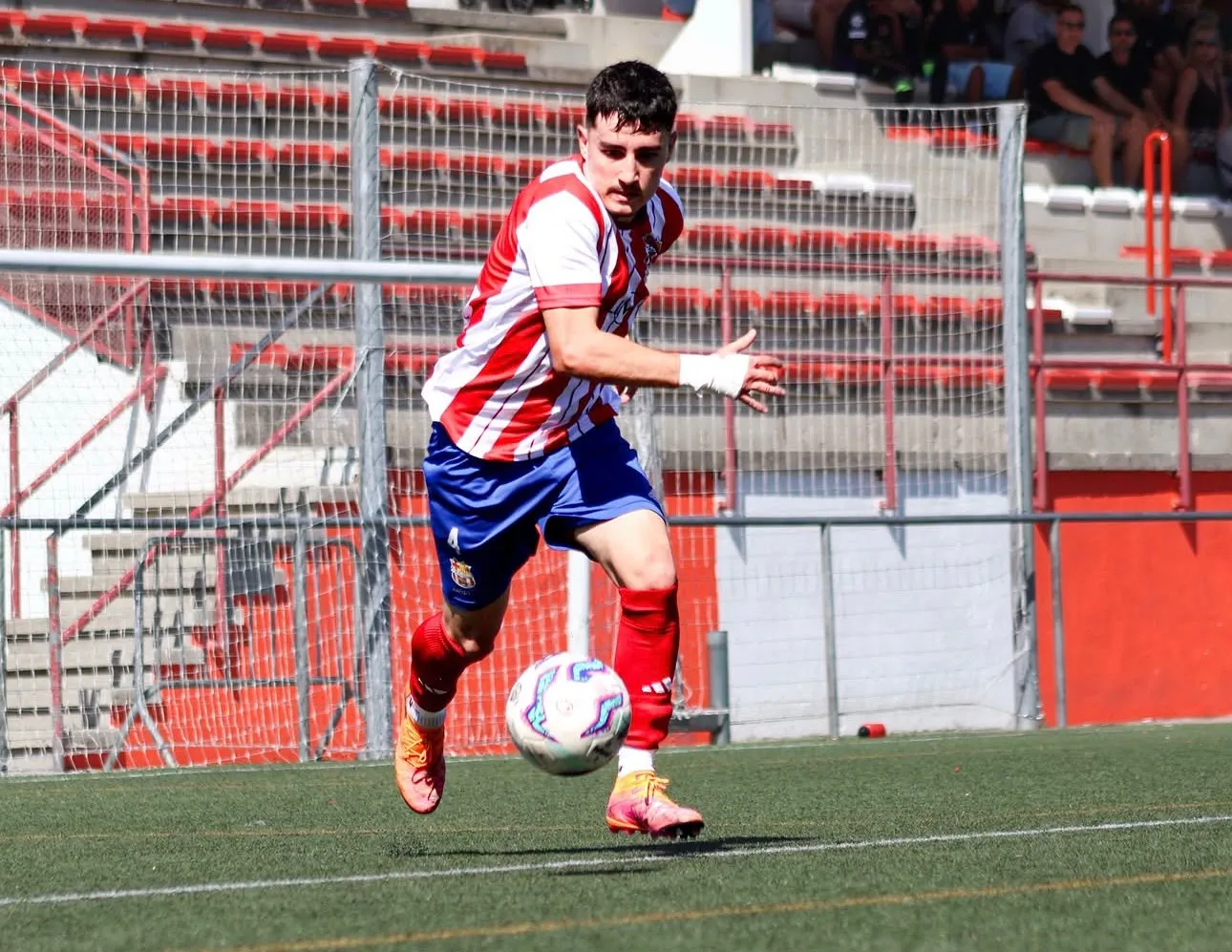 Jugador del FC Cardedeu corrent amb la pilota a l'estadi
